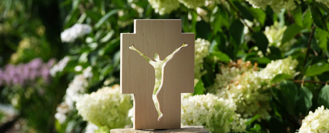 Ein Holzkreuz vor grünem Hintergrund