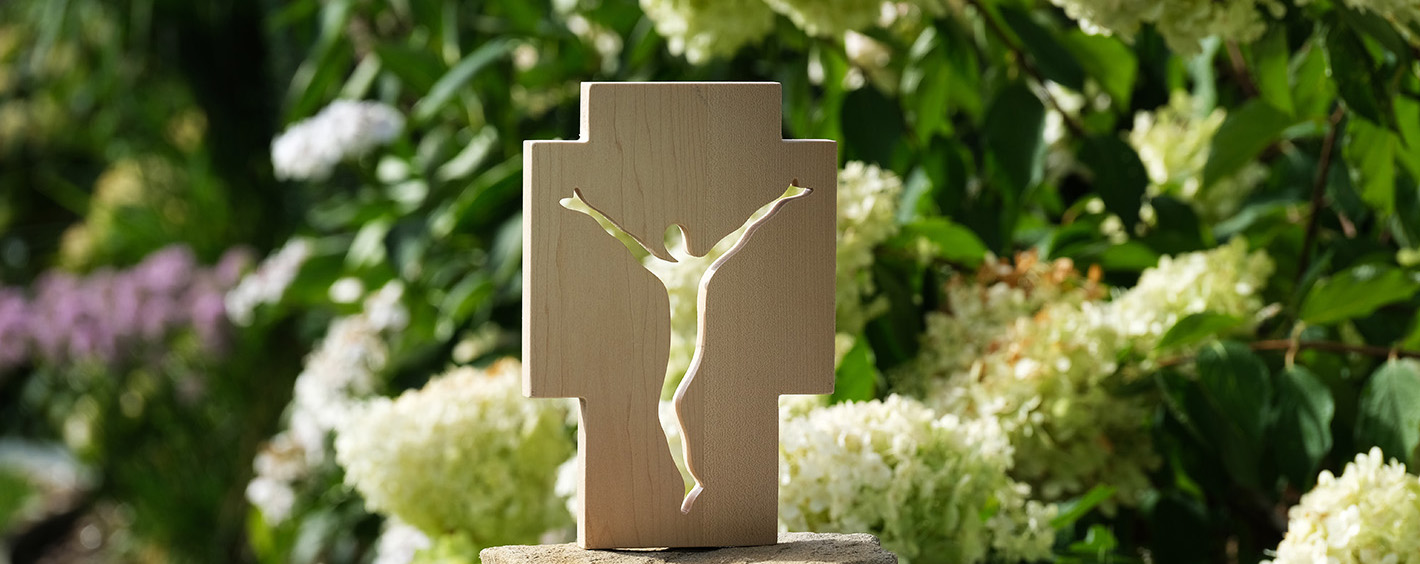 Ein Holzkreuz vor grünem Hintergrund