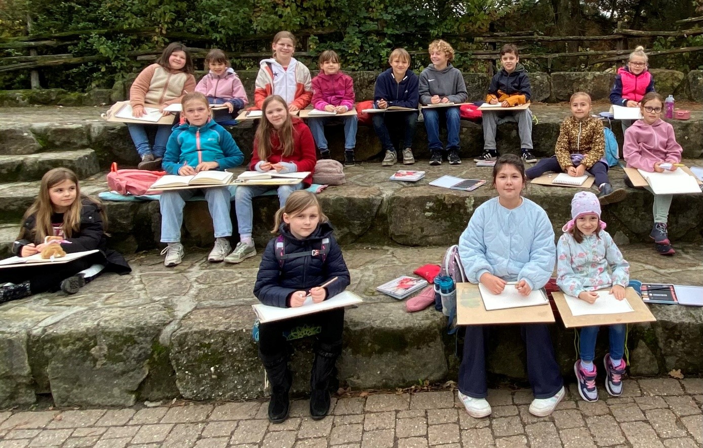 Die Kinder zeichnen vor dem Seehundbecken im Zoo in Rheine.