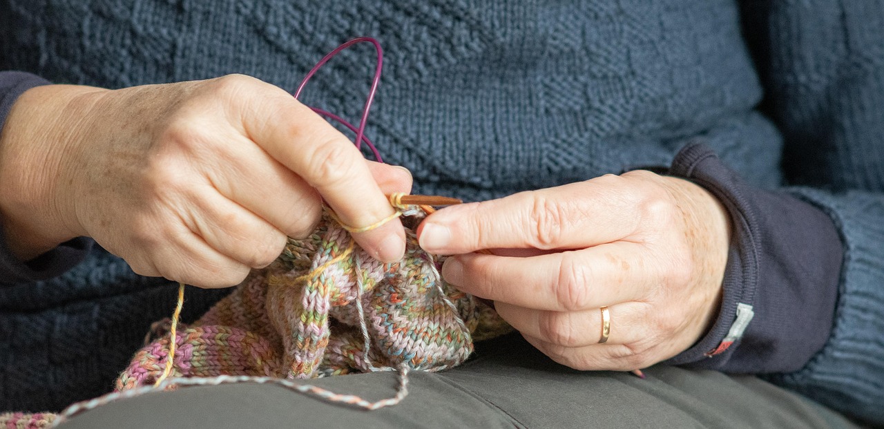 Frauenhände mit kreativer Strickarbeit